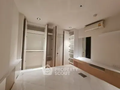 Spacious bedroom with built-in wardrobes and modern lighting