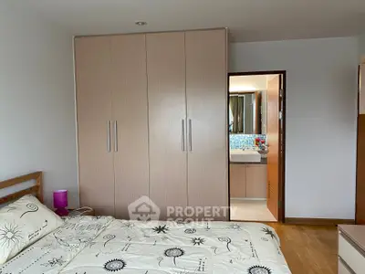 Cozy bedroom with built-in wardrobe and ensuite bathroom, featuring modern decor and natural light.