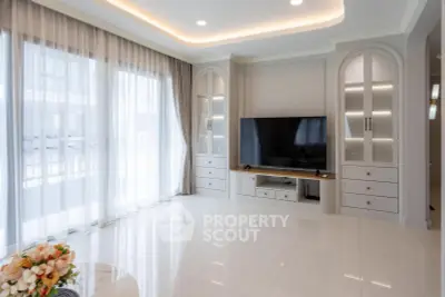Spacious modern living room with large windows and elegant built-in cabinetry.