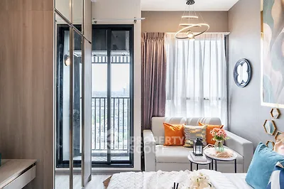 Modern bedroom with balcony view, stylish decor, and cozy seating area.