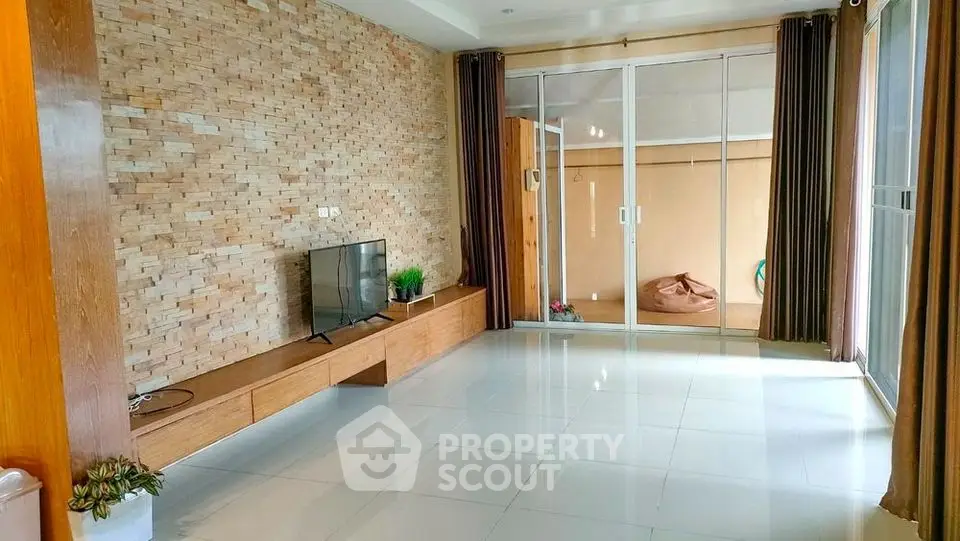 Spacious living room with modern decor and sliding glass doors to balcony