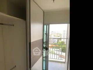 Compact balcony with sliding door and city view in modern apartment.