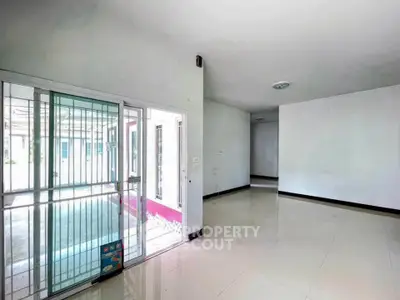 Spacious empty room with large windows and sliding glass door, ideal for customization.