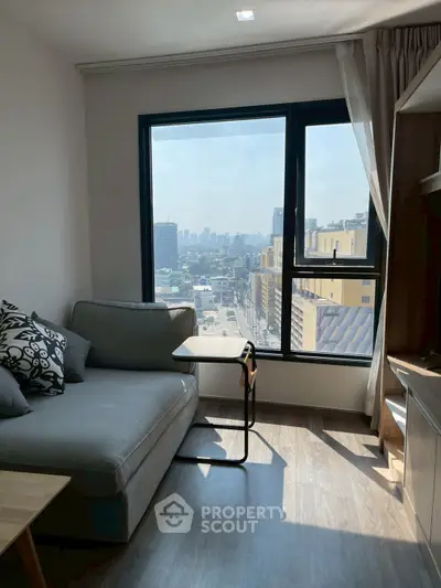 Modern living room with city view, featuring a cozy sofa and natural light.
