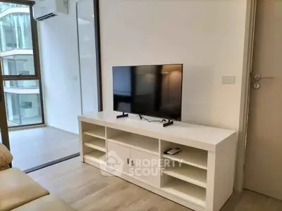 Modern living room with sleek TV stand and large window view.
