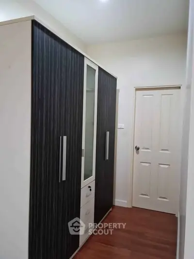 Spacious hallway with modern wardrobe and wooden flooring in a stylish apartment.