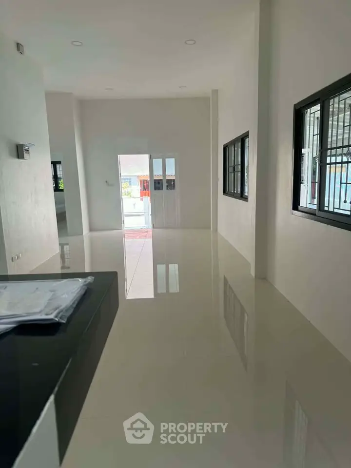 Spacious modern living room with glossy tiled floors and large windows for natural light.