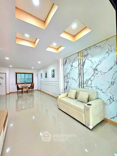 Spacious modern living room with elegant marble accent wall and recessed lighting