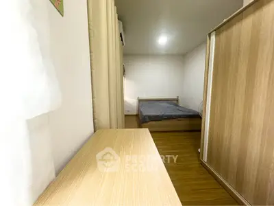 Cozy bedroom with wooden flooring and modern furnishings, perfect for relaxation.