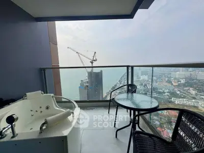 Luxurious balcony with jacuzzi offering stunning city and ocean views.