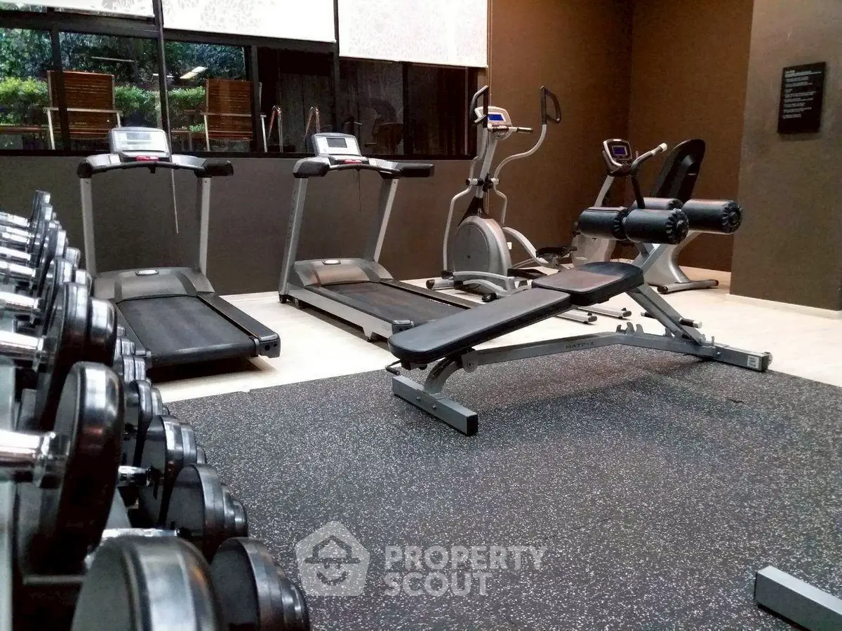 Modern gym with treadmills and weights in luxury apartment complex