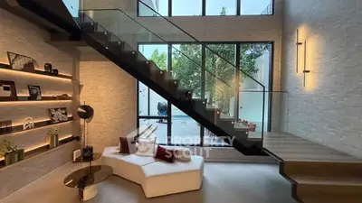 Stunning modern living room with glass staircase and high ceilings