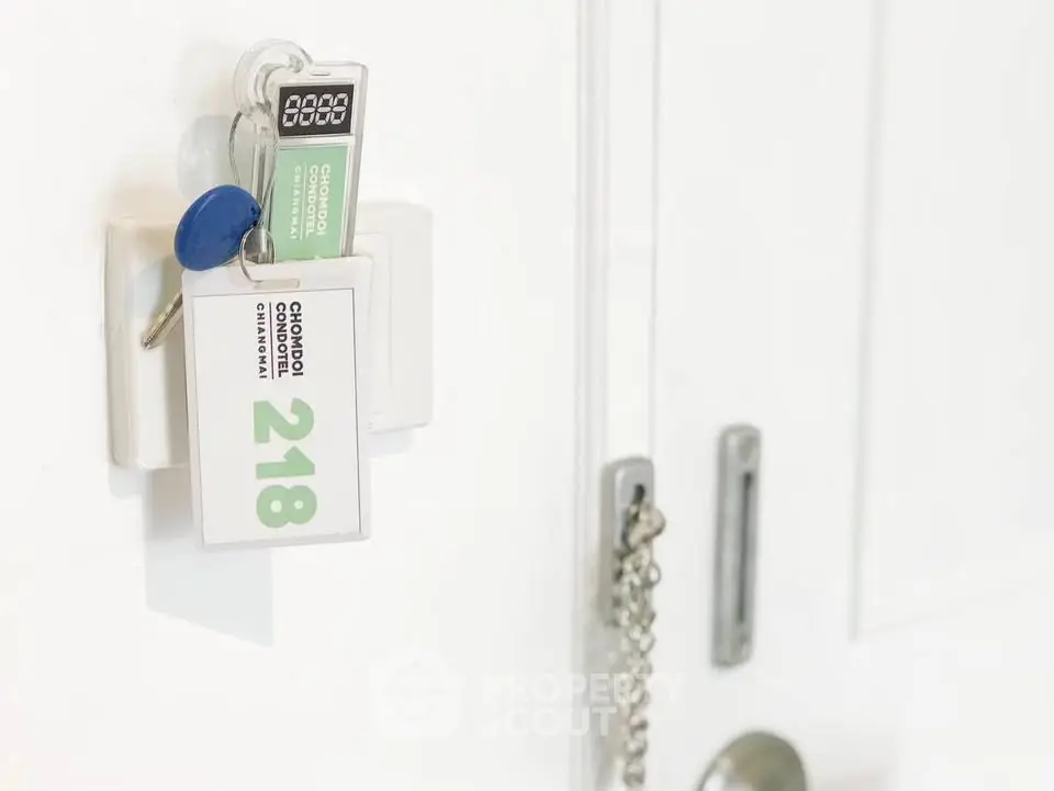 Close-up of a door with keys and a keycard, showcasing secure entry features.