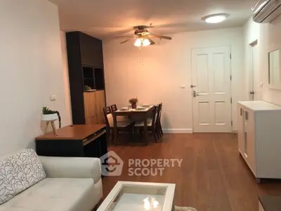 Charming living room with dining area, featuring wooden flooring and modern furniture in a cozy apartment.