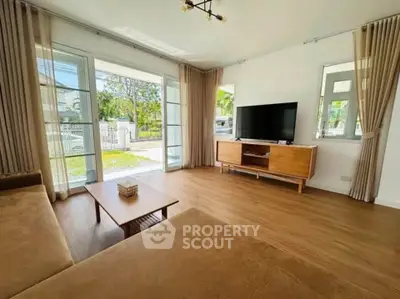 Spacious living room with modern decor and large windows offering natural light.