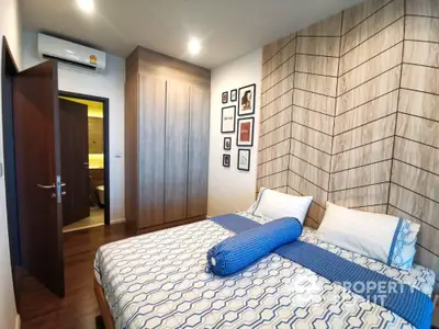 Modern bedroom with stylish wood paneling and cozy bedding in a contemporary apartment.