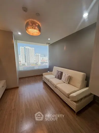 Modern living room with city view, featuring elegant lighting and cozy seating.