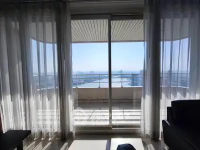 Stunning balcony view with floor-to-ceiling windows overlooking a serene waterfront.