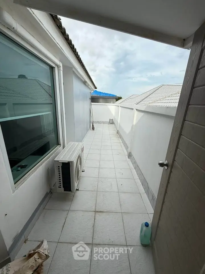 Spacious rooftop balcony with tiled flooring and air conditioning unit, perfect for relaxation.