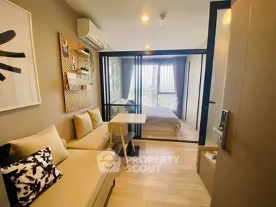 Modern apartment with cozy living area and glass-walled bedroom, featuring stylish decor and natural light.