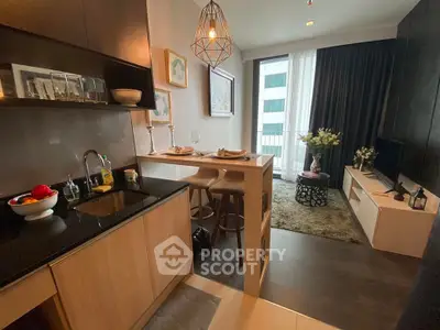 Modern open-layout kitchen and living room with stylish decor and natural light.