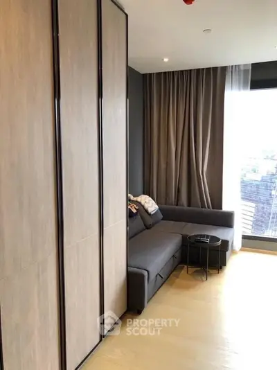 Modern living room with sleek design and large window offering natural light.
