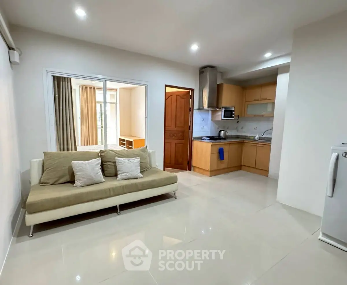 Modern open-plan living room and kitchen with sleek design and natural light.