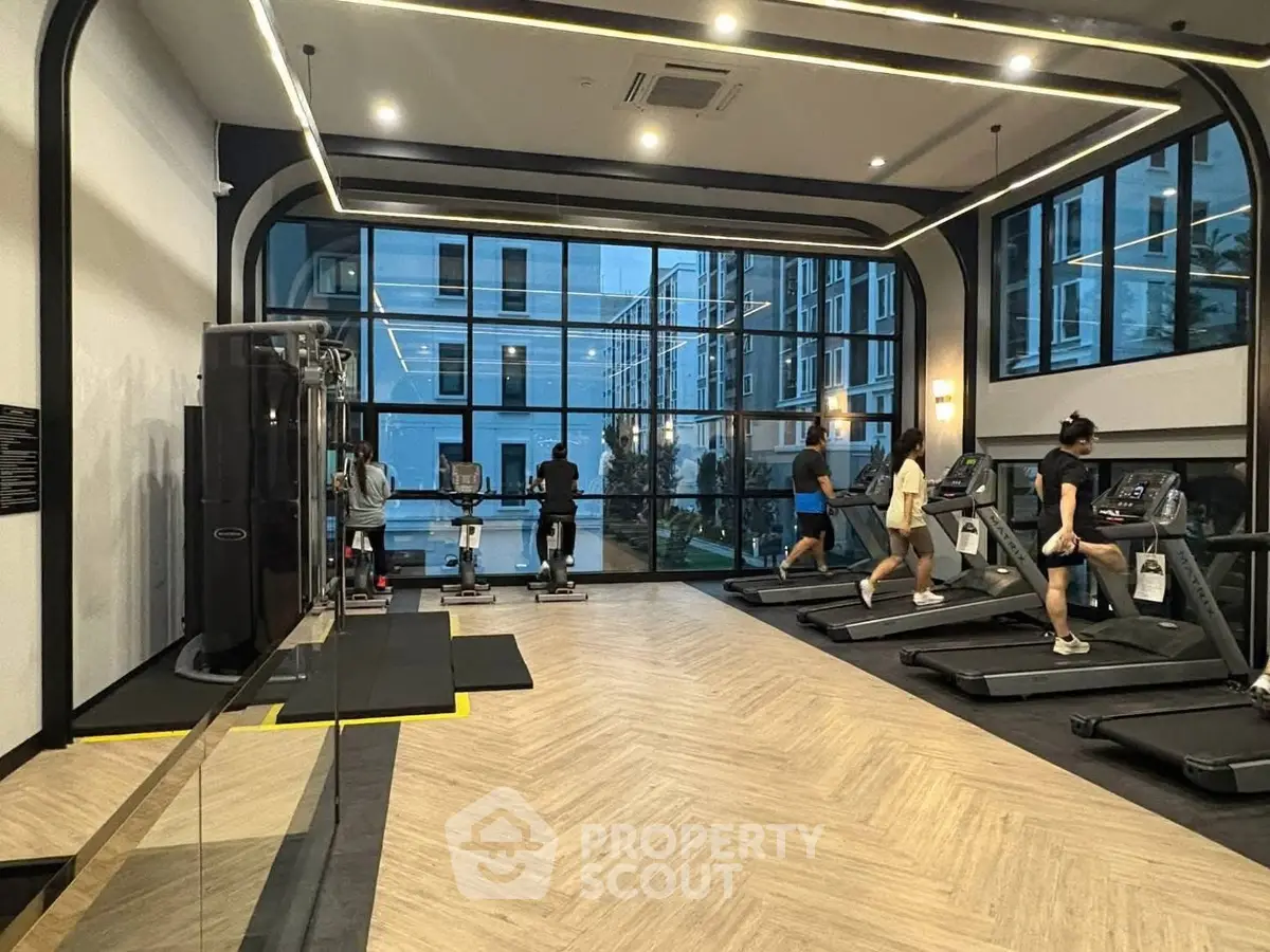 Modern gym with large windows and fitness equipment in luxury apartment building