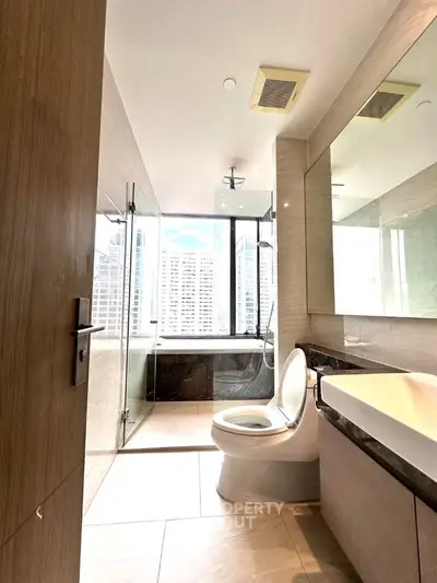 Modern bathroom with city view, featuring glass shower and sleek design.