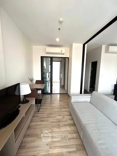 Modern living room with sleek furniture and wooden flooring in a stylish apartment.