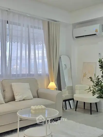 Elegant living room with cozy sofa, stylish decor, and natural light through large window.