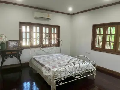 Charming bedroom with elegant metal bed frame and wooden windows