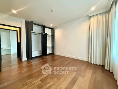 Spacious bedroom with open closets and hardwood floors, ideal for modern living.