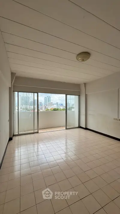 Spacious empty living room with large windows offering stunning city views, perfect for customization.