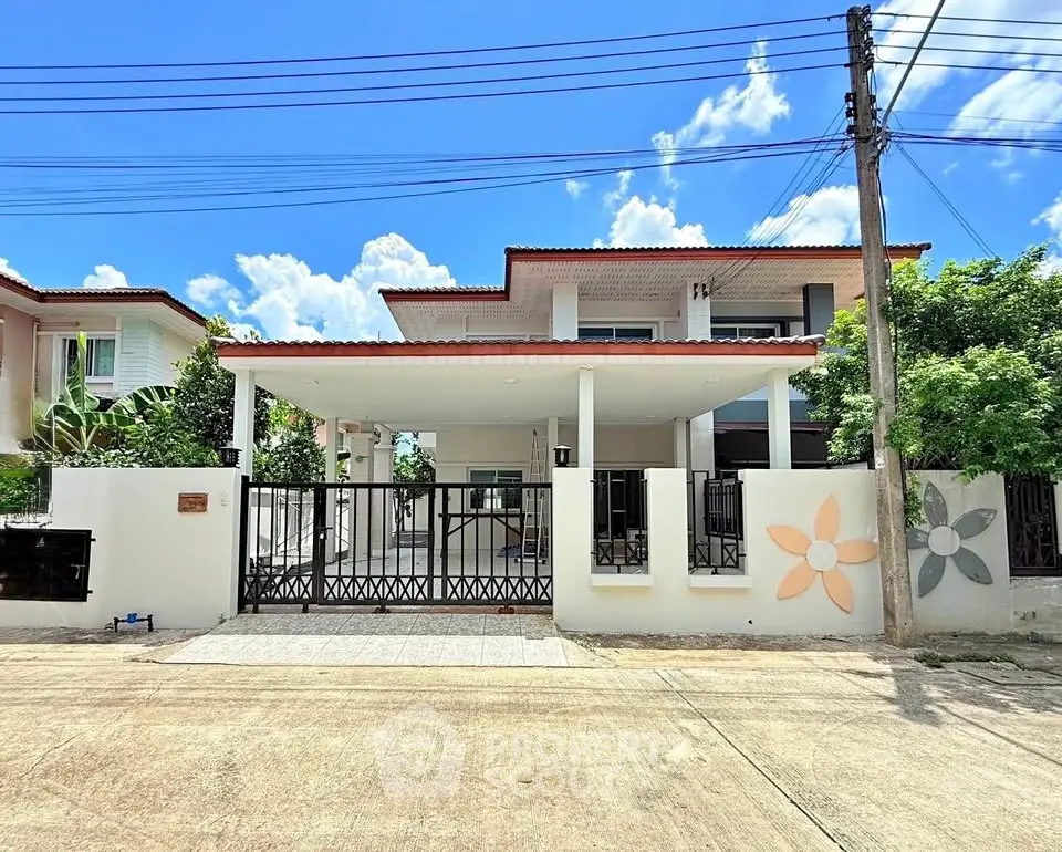 Modern two-story house with gated entrance and spacious driveway under clear blue sky.