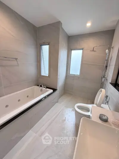 Luxurious modern bathroom with sleek design and spacious bathtub, perfect for relaxation.