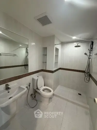 Modern bathroom with sleek fixtures and spacious shower area in a contemporary home.