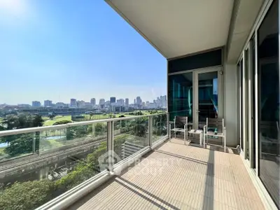 Spacious balcony with stunning city skyline view and glass railing.