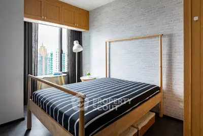 Modern bedroom with city view, featuring stylish wooden bed and striped bedding, ideal for urban living.
