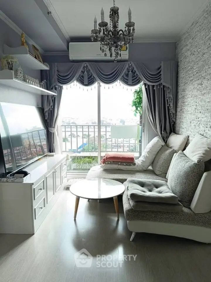 Chic living room with elegant decor, large TV, and balcony view in modern apartment.