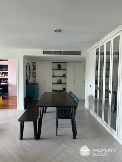 Modern dining room with sleek table and chairs, mirrored cabinets, and stylish decor.