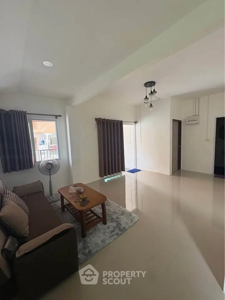 Spacious living room with modern decor and natural light, perfect for relaxation and entertaining.