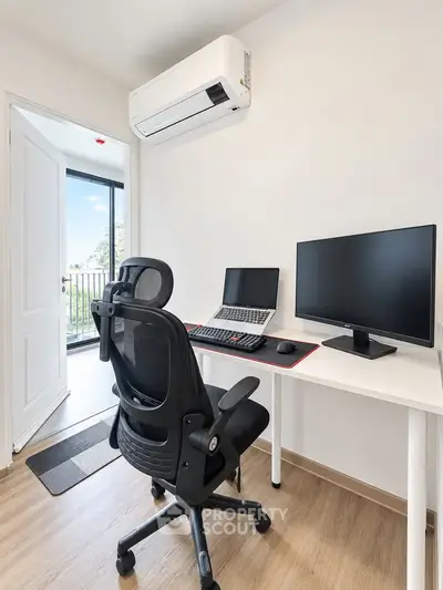 Modern study room with desk, chair, and dual monitors, featuring a balcony view and air conditioning.
