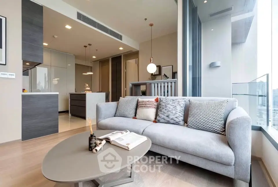 Modern living room with stylish decor and open kitchen layout in a high-rise apartment.