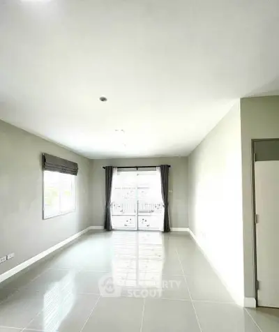 Spacious empty living room with large windows and glossy tiled floor