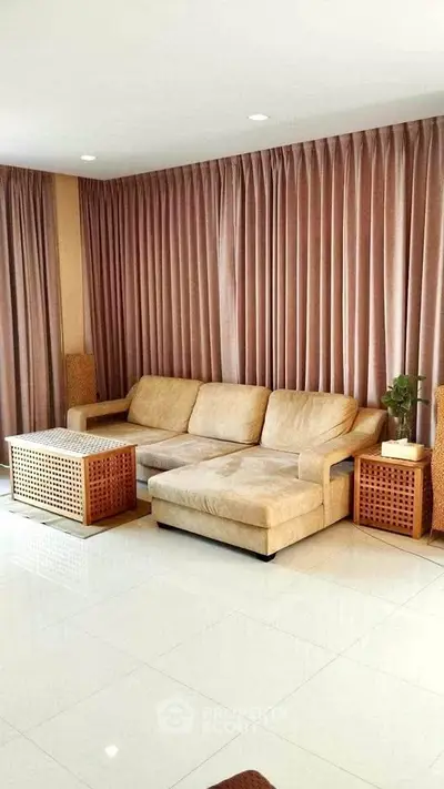 Spacious living room with elegant beige sofa and stylish side tables, perfect for relaxation and entertaining.