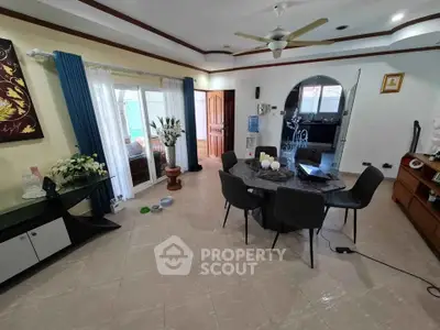 Spacious living room with modern decor and dining area, featuring elegant furniture and natural light.