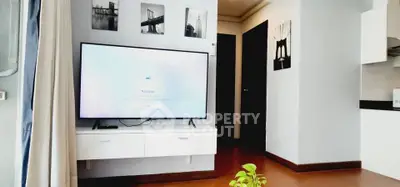 Modern living room with sleek TV setup and stylish decor in a contemporary apartment.