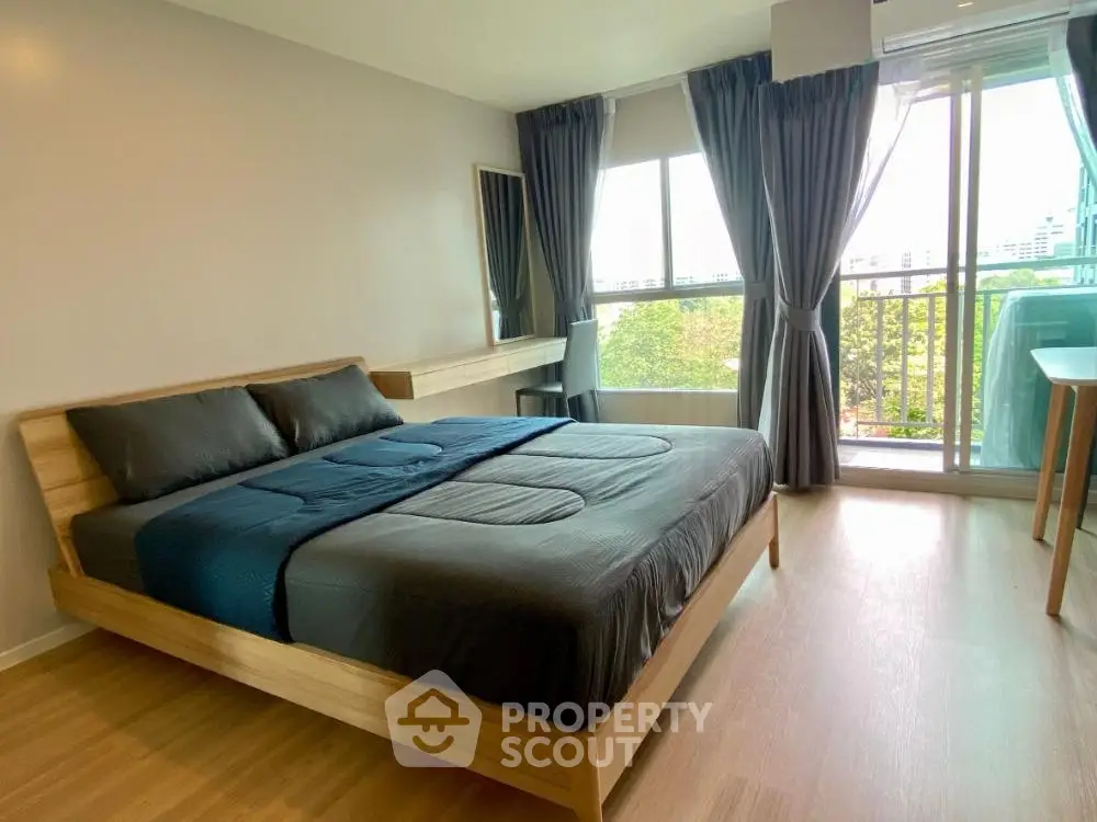 Spacious bedroom with modern decor and large windows offering a scenic view.