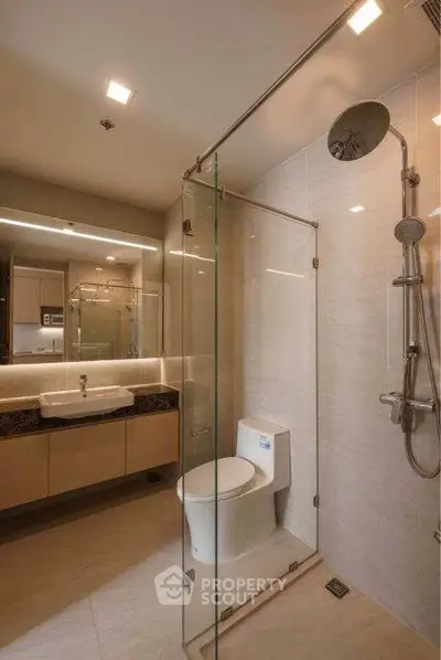 Modern bathroom with glass shower and sleek fixtures in a contemporary apartment.